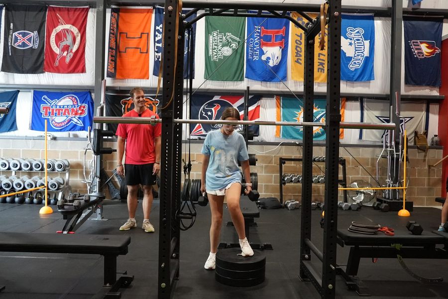 A coach working with an athlete on the training floor